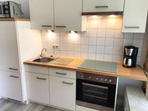eine Küche mit weißen Schränken und einer Spüle in der Unterkunft 3-Sterne Komfortferienwohnung  Köhnke 6 - [#122261] in Goslar