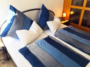 ein Bett mit blauen und weißen Kissen darauf in der Unterkunft 3-Sterne Komfortferienwohnung  Köhnke 6 - [#122261] in Goslar