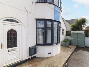 a white building with a door and a window at Flat 1 Niles Place in Padstow