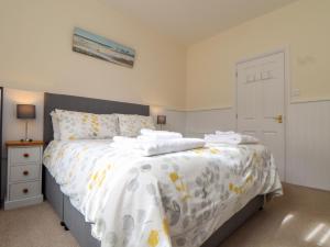 a bedroom with a bed with a white comforter at Flat 1 Niles Place in Padstow