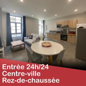 a living room with a table and a kitchen at 45m² rez-de-chaussée au calme centre-ville in Mayenne