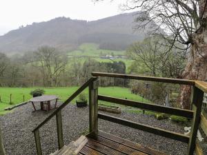 a wooden stairway with a bench and a table at Graig Las The Barn in Oswestry