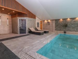 uma piscina num quarto com um sofá e uma mesa em Lodge 3 em St Asaph