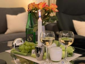 einen Tisch mit zwei Gläsern Weißwein und Trauben in der Unterkunft 4-Sterne Premiumferienwohnung  Köhnke 3 - [#122258] in Goslar