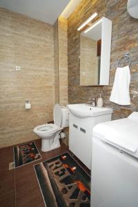 a bathroom with a toilet and a sink and a mirror at Todor Apartmani in Kladovo