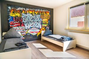 ein Schlafzimmer mit einer mit Graffiti bedeckten Wand in der Unterkunft Große Monteurunterkunft `All-inn` bei Mainz in Ebersheim in Mainz