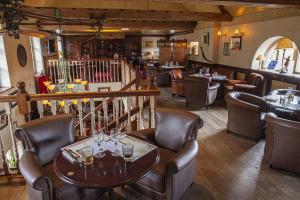 un restaurant avec des chaises et une table avec des verres à vin dans l'établissement La Chartreuse Du Val Saint Esprit, à Gosnay