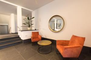 a waiting room with orange chairs and a mirror at NEU - MoselAUSZEIT Traben in Traben-Trarbach +47 photos