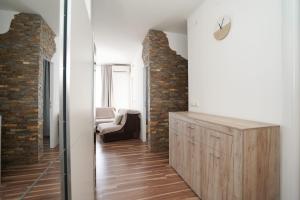 a living room with a wooden dresser and a brick wall at Todor Apartmani in Kladovo