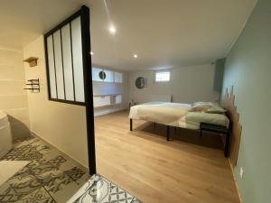 1 dormitorio con cama y espejo grande en La P'tite Loupiote, en La Loupe