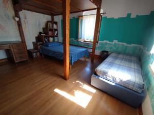 1 Schlafzimmer mit 2 Betten und einem Himmelbett in der Unterkunft B&B Vallata in Vallata