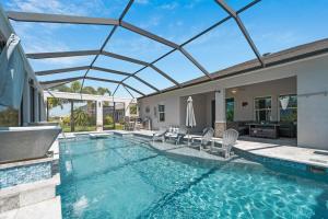 uma piscina com um telhado de vidro sobre ela em High-End Gulf Getaway with Pool & Hot Tub em Port Charlotte