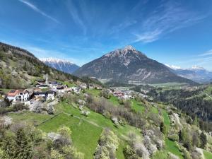 a village on a hill with a mountain in the background at Apart Alpenzeit in Arzl im Pitztal
