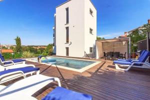 eine Terrasse mit einem Pool und Stühlen sowie ein Haus in der Unterkunft Ferienhaus für 10 Personen in Pjescana Uvala, Istrien Istrische Riviera in Pješčana Uvala
