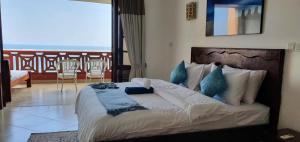 La Mera Beachfront Apartment في مومباسا: غرفة نوم بسرير كبير مع شرفة