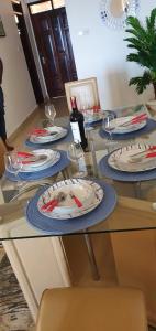 a table with plates and wine glasses on it at La Mera Beachfront Apartment in Mombasa