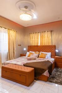 a bedroom with a large bed with yellow curtains at THE OPULENT OASIS in Accra