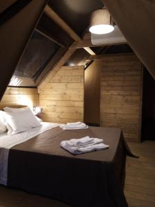 1 dormitorio con 1 cama con 2 toallas en Glamping - La Giara en San Demetrio Corone