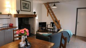 a living room with a table and a fireplace at Le Moulin du Clapier La Banette in Sorges