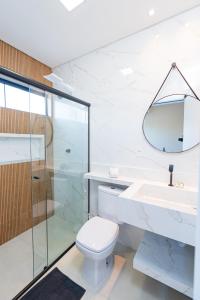 La salle de bains est pourvue de toilettes, d'un lavabo et d'une douche. dans l'établissement Pousada Kauai SFS, à São Francisco do Sul