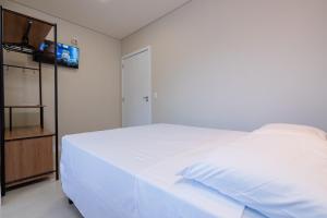 南聖法蘭西斯科的住宿－Pousada Kauai SFS，卧室配有一张白色大床和电视。