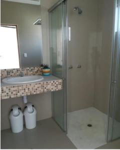 a bathroom with a glass shower and a sink at Casa los Vientos de Vichayito in Los Órganos