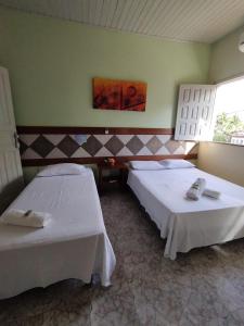 a room with two beds in a room at Pousada Arco Iris Ilhéus in Ilhéus