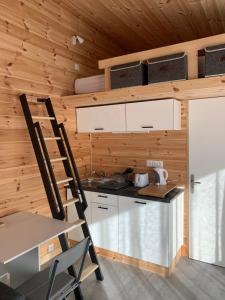a kitchen with a table and a chair in a cabin at Eco-Lodge de Cëuse in Sigoyer