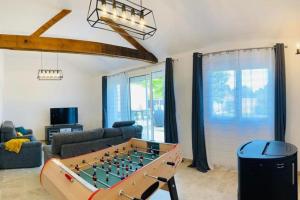 ein Wohnzimmer mit Tischfußball in der Unterkunft Le Catalpa, gite avec piscine et jacuzi privés in Lestiou