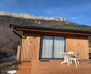 een kleine hut met een tafel en stoelen op een terras bij Eco-Lodge de Cëuse in Sigoyer
