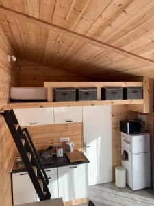 een keuken met witte kasten en een houten plafond bij Eco-Lodge de Cëuse in Sigoyer