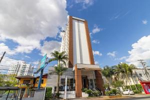 a tall building with palm trees in front of it at Loft mobiliado no centro de Blumenau in Blumenau