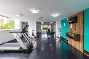 a gym with a treadmill and bikes in a room at Loft mobiliado no centro de Blumenau in Blumenau