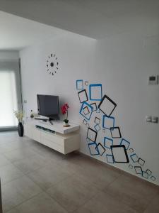 a living room with a wall with pictures on it at Villa Amalia Fase 2 APR. 35 in Torrevieja
