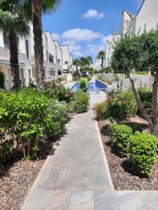 a walkway in front of a building with trees and bushes at Villa Amalia Fase 2 APR. 35 in Torrevieja