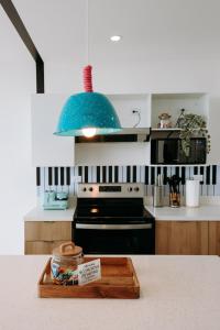 a kitchen with a table with a wooden cutting board at ¡Sivar Sound! Music Design! in San Salvador