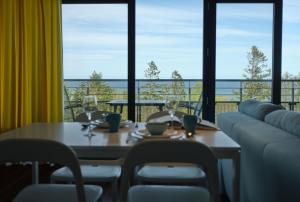 - une salle à manger avec une table et une vue sur l'océan dans l'établissement Najpiękniejszy Widok na Bałtyk - Twój Apartament, à Sarbinowo