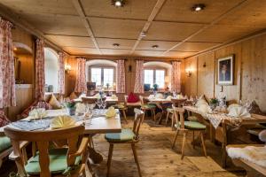 um restaurante com paredes e mesas e cadeiras de madeira em Berghaus - Der Westerhof Hotel em Tegernsee