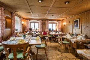 a restaurant with wooden walls and tables and chairs at Berghaus - Der Westerhof Hotel in Tegernsee