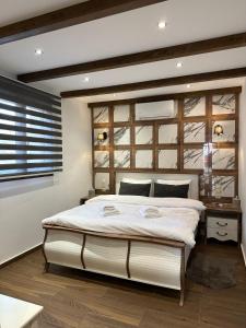 a bedroom with a large white bed and a window at ERIETTA-AGAPI #1 in Kalabaka +18 photos