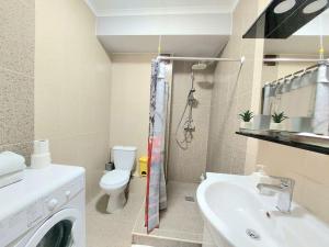 La salle de bains est pourvue d'un lave-linge et d'un lavabo. dans l'établissement Комфортная студия в новострое на Ботанике., à Chişinău