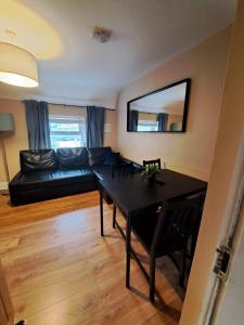 a living room with a black couch and a table at Apt in Stoneybatter D7 in Dublin