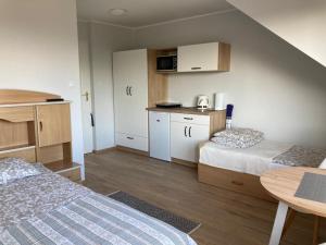 Cette petite chambre comprend deux lits et une table. dans l'établissement Magdalena, à Karwia