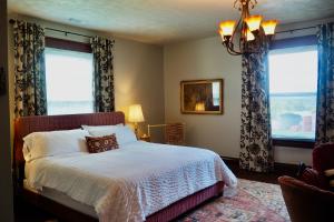 a bedroom with a bed and two windows at Firefly Hills in Beattyville