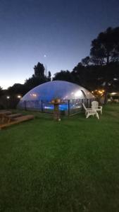 ein großes Kuppelgebäude mit einer Bank auf einem Feld in der Unterkunft Tierra Mansa - Posada de Campo & Spa - Piscina Climatizada in Marcos Paz