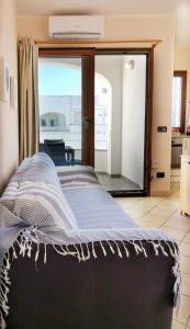 a bed in a room with a view of a balcony at Relax Home in La Caletta +39 photos