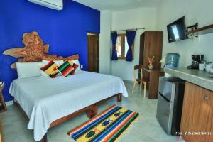 Mar y Sueños Suites في سايوليتا: غرفة نوم بسرير كبير بجدار ازرق