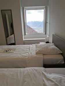 1 dormitorio con 2 camas y ventana en Résidence Alpina Caux, en Montreux