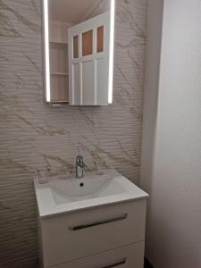 bagno con lavandino bianco e specchio di Résidence Alpina Caux a Montreux