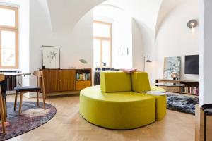 ein Wohnzimmer mit einem gelben Stuhl und einem Tisch in der Unterkunft Marktplatz-Residenz - 110 m vom Traunsee in Gmunden